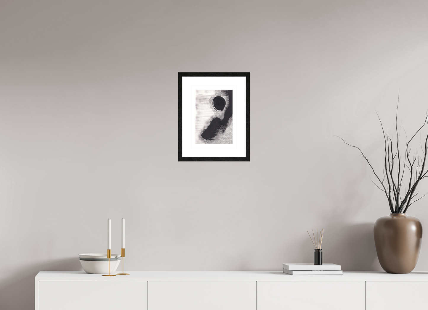 L'image représente un tableau abstrait à l'encre noire sur fond blanc. C'est une oeuvre de l'artiste peintre Maeva J., son titre est "Mirage". Elle est présentée dans un cadre noir accroché au mur.