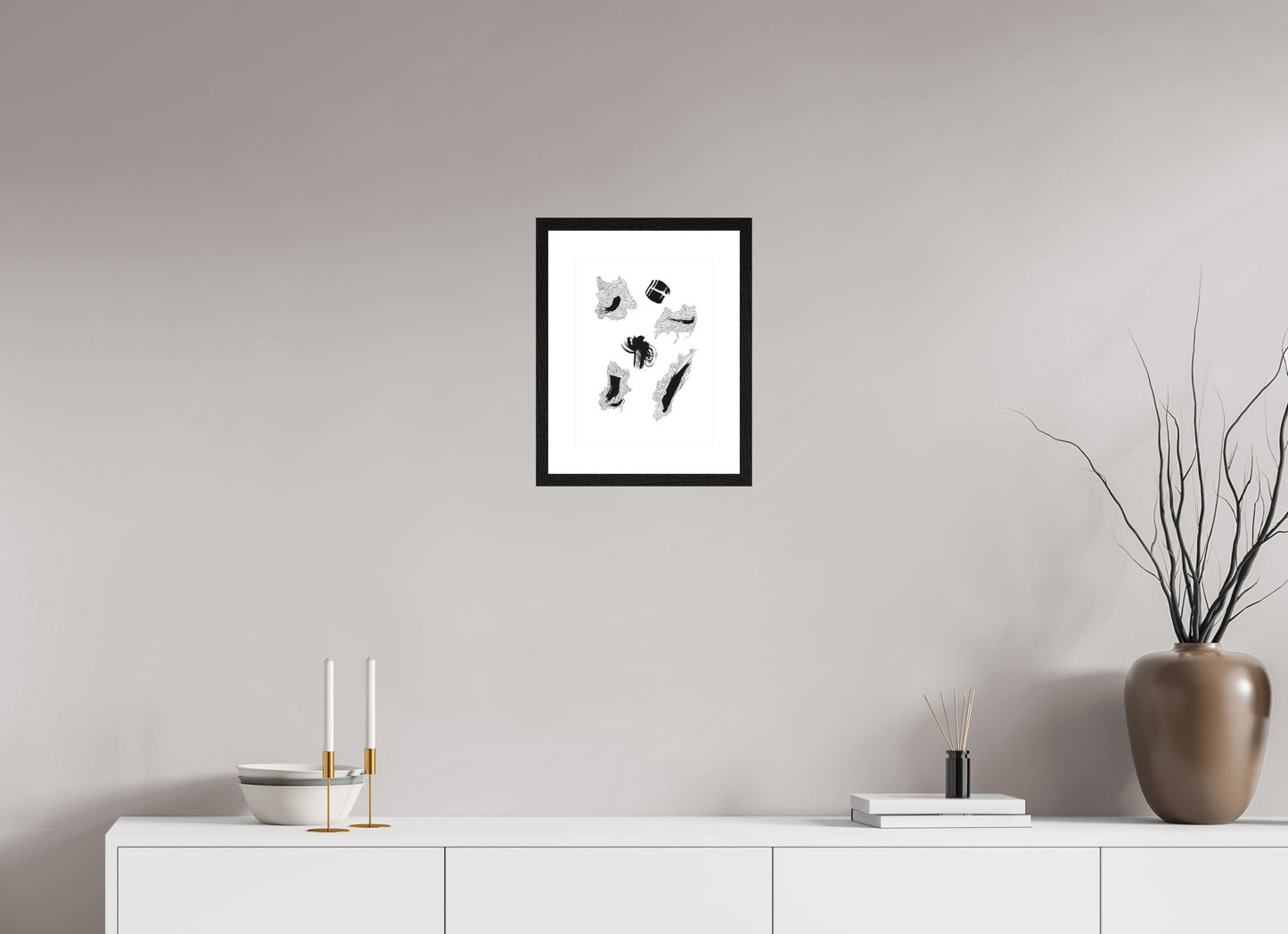 L'image représente un tableau abstrait à l'encre noire sur fond blanc. C'est une oeuvre de l'artiste peintre Maeva J., son titre est "Partition". Elle est présentée dans un cadre noir accroché au mur.