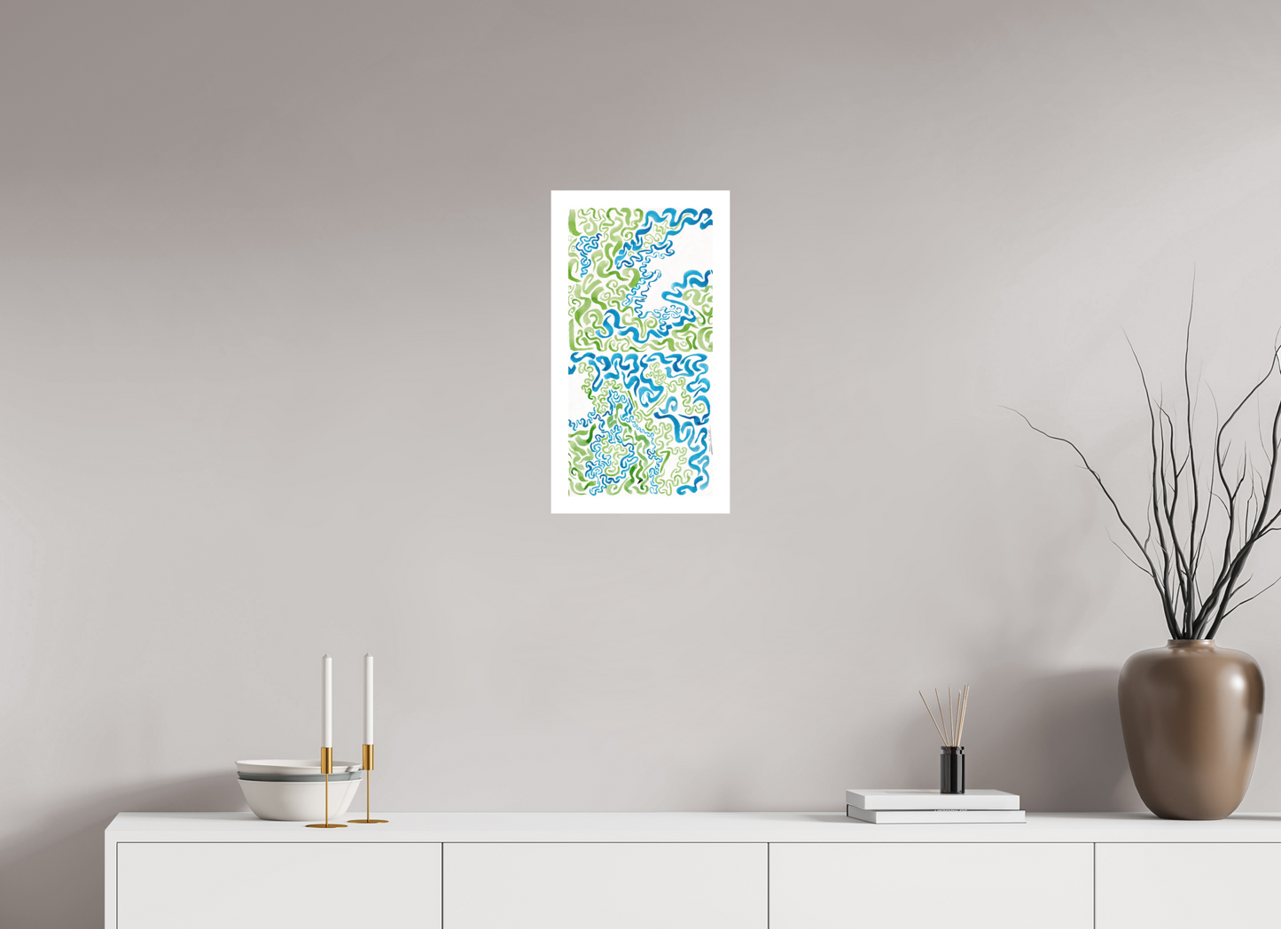 L'image représente un tableau abstrait à l'encre verte et bleue, affiché dans une pièce lumineuse. C'est une oeuvre de l'artiste peintre Maeva J.