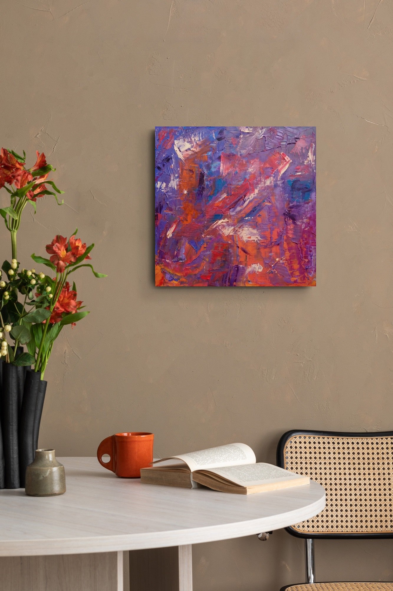 L'image représente un tableau abstrait aux couleurs violet, bleu, rouge-orange. Ses dimensions sont de 50 cm par 50 cm. Il a été créé à la peinture à l'huile avec un travail au couteau et à la cire froide. Il présente des empâtements et des reliefs, des traits expressifs. Le tableau a été peint à la peinture à l'huile par la peintre autodidacte Maeva J.