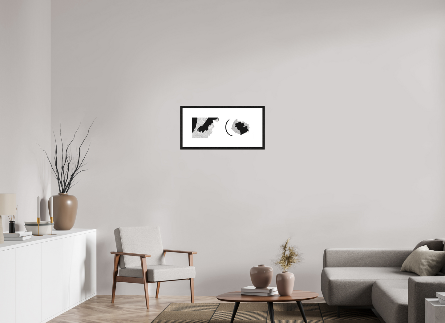 L'image représente un tableau abstrait à l'encre noire sur fond blanc. C'est une oeuvre de l'artiste peintre Maeva J., son titre est "Rencontres". Elle est présentée dans un cadre noir accroché au mur.