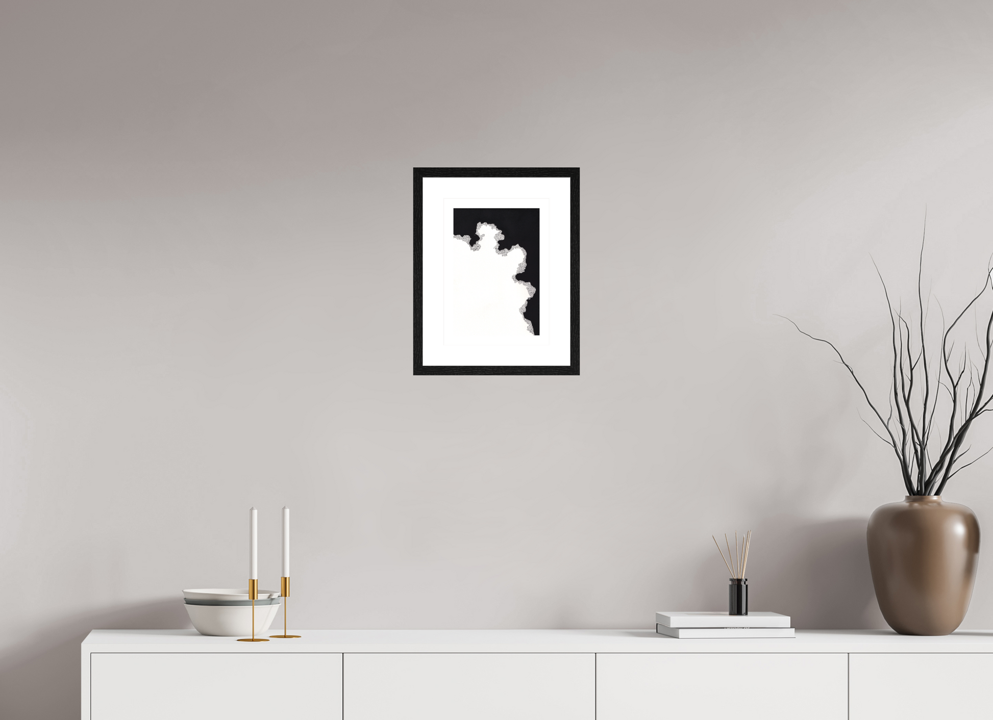 L'image représente un tableau abstrait à l'encre noire sur fond blanc. C'est une oeuvre de l'artiste peintre Maeva J., son titre est "Cadence". Elle est présentée dans un cadre noir accroché au mur.